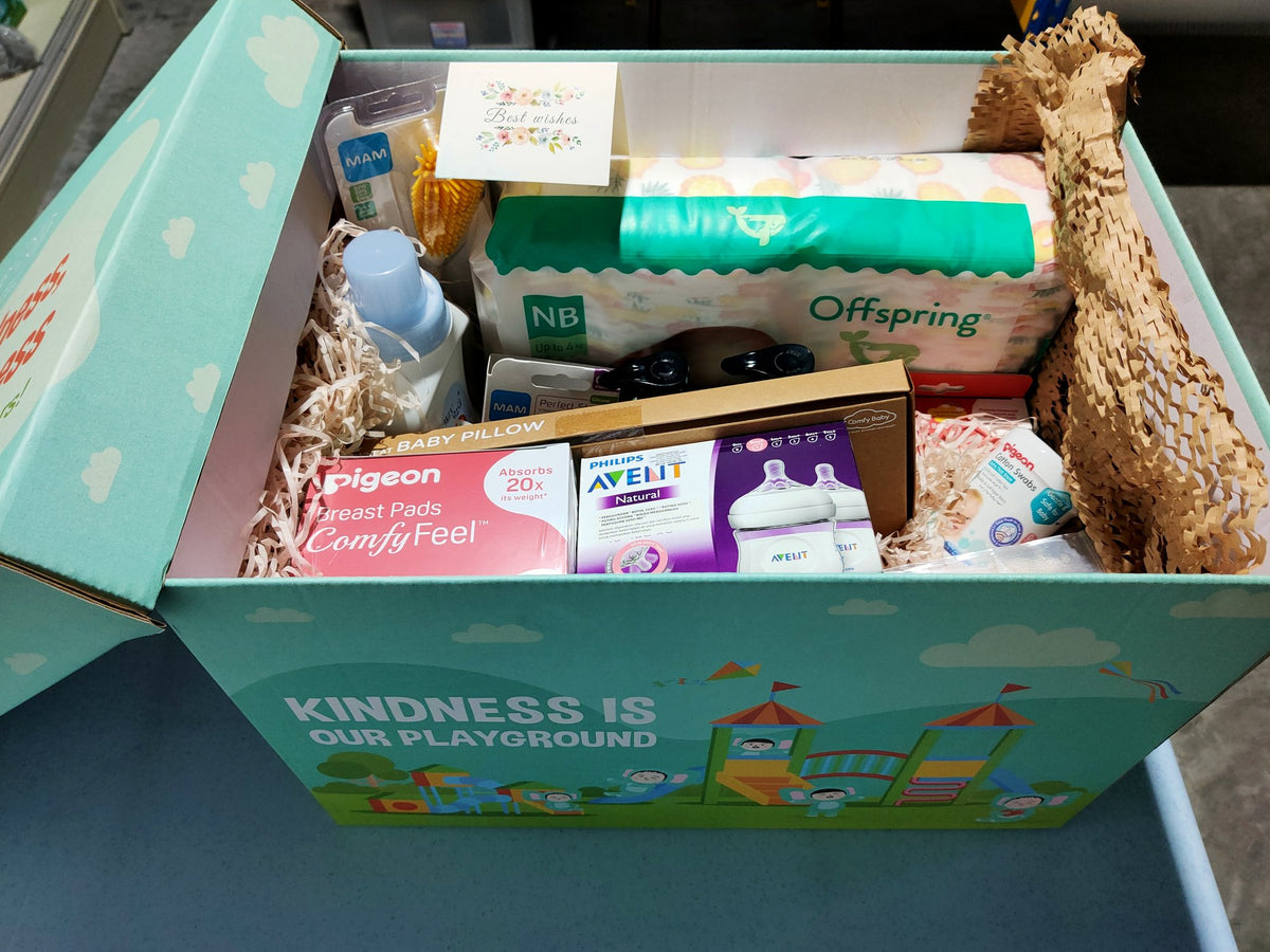 A Happy Kind Kiddo gift box packed with diapers, feeding bottles, breast pads and baby care items